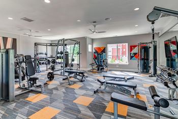 a gym with weights and cardio equipment and a window